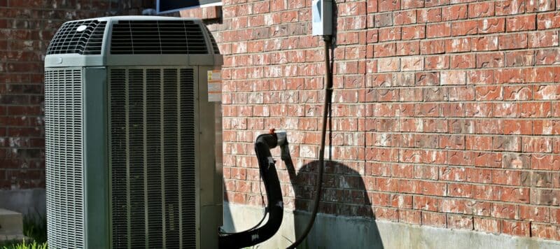 outdoor hvac unit outside of a brick house